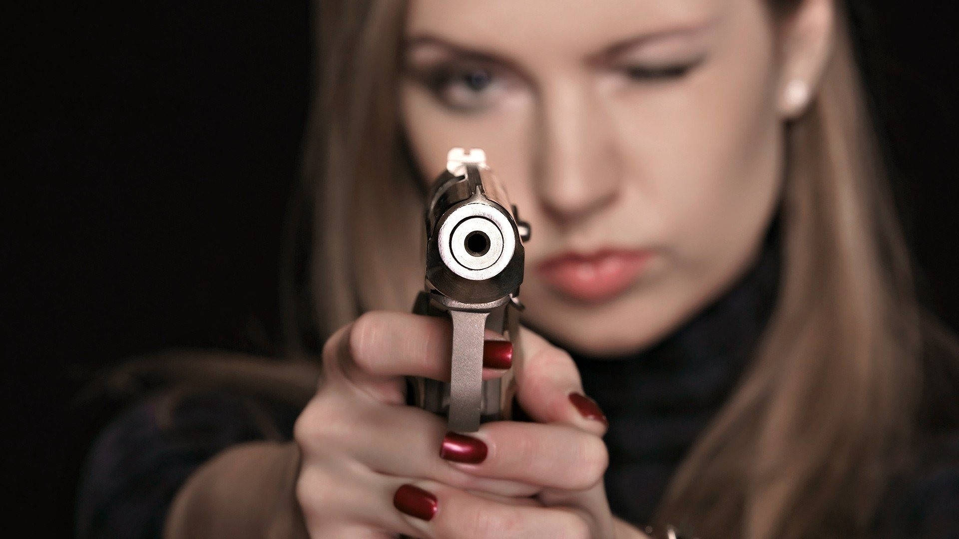 Kvinde peger og skyder en pistol Wallpaper