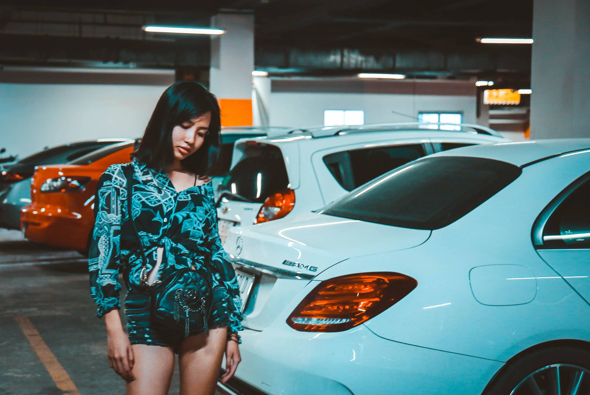 Confident Woman Posing in a Spacious Parking Lot Wallpaper