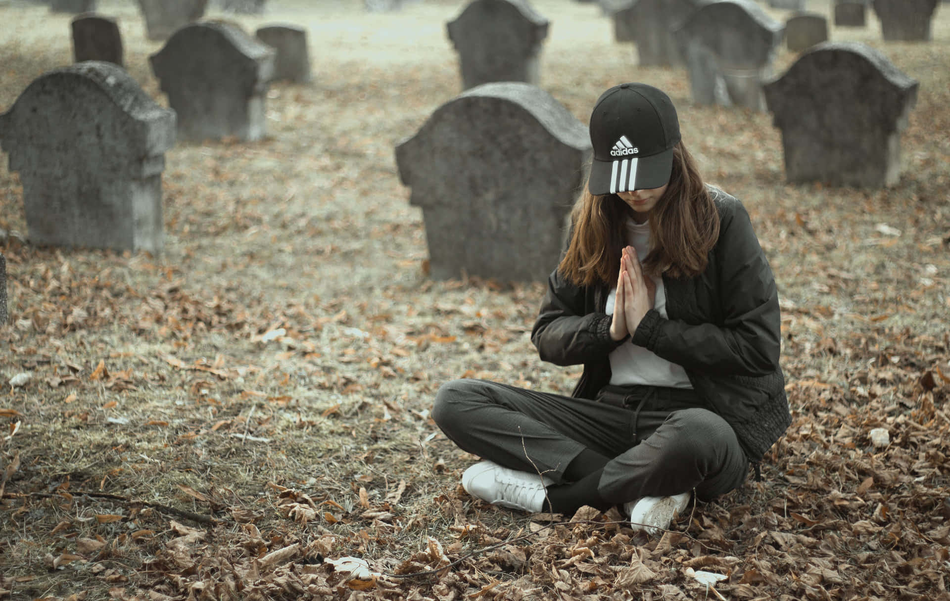 Woman Praying At A Cemetery Wallpaper