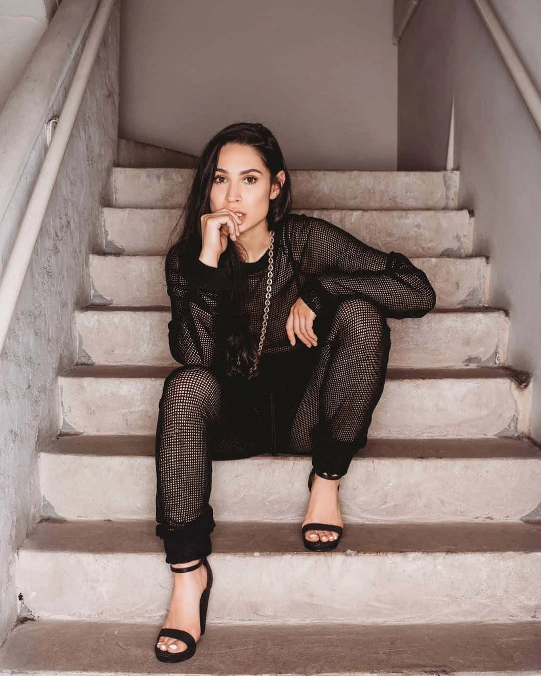 Woman Seatedon Staircasein Black Outfit Wallpaper