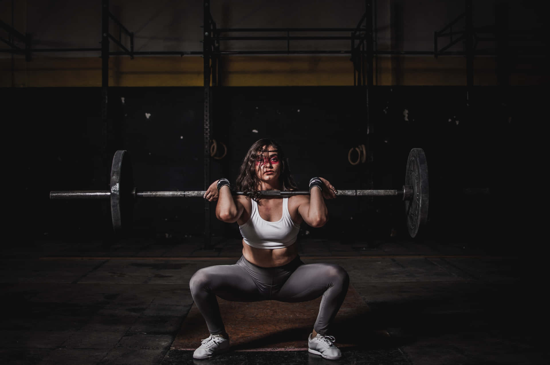 Woman Squatting During Weight Training Wallpaper