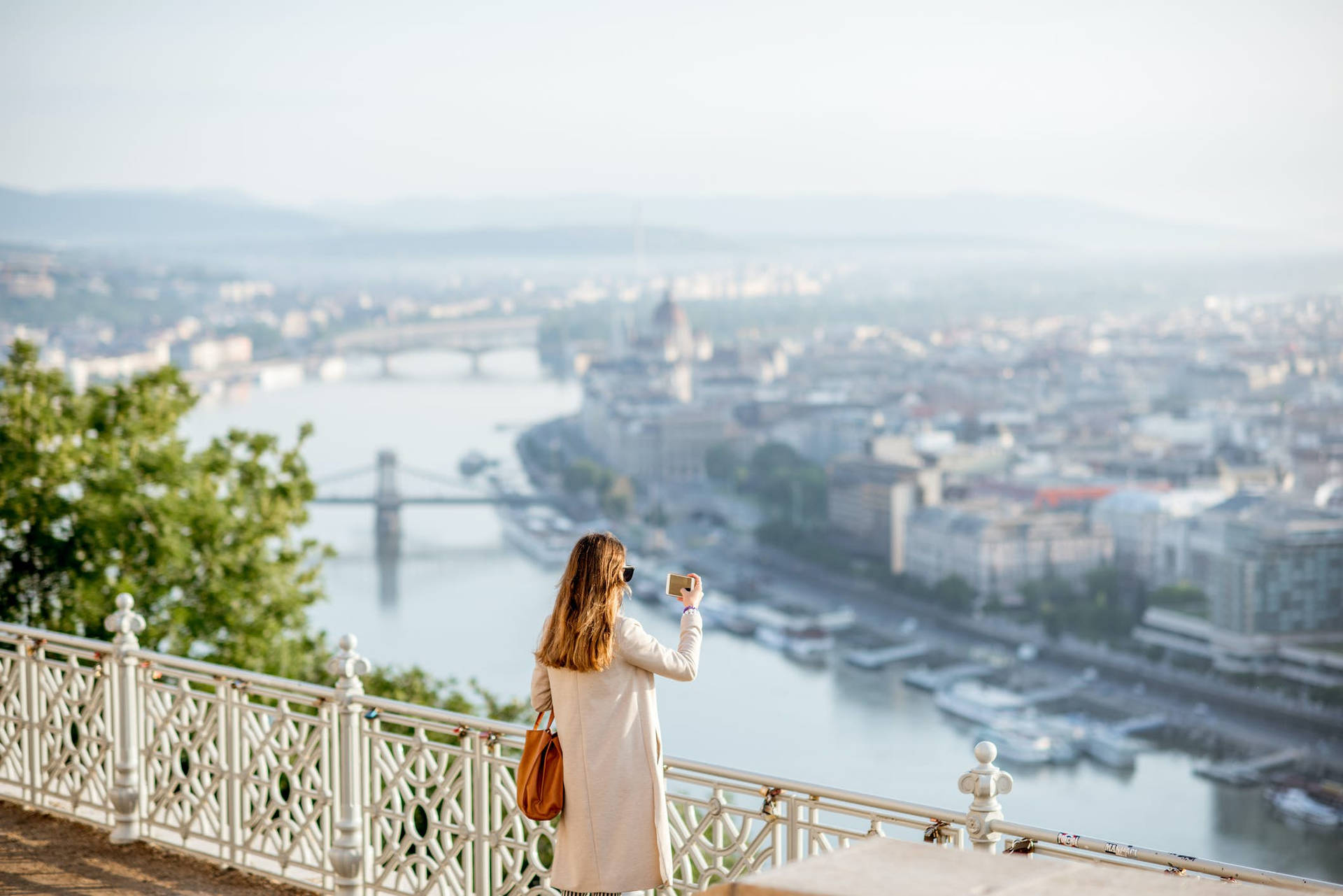 a woman is standing on a balcony overlooking the river danube Wallpaper