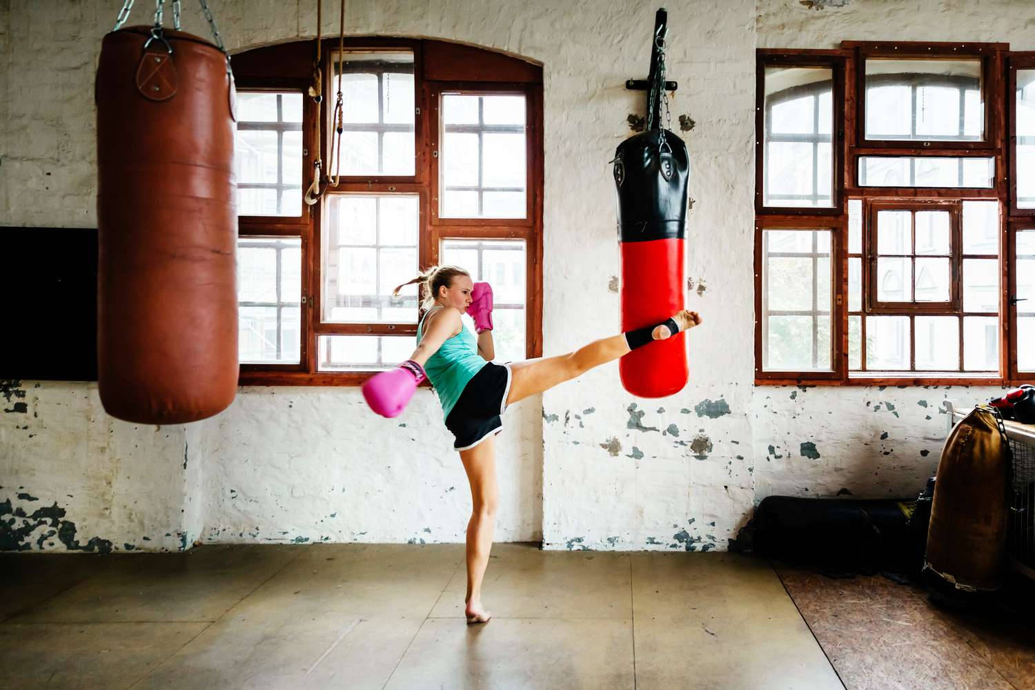 Kvinde træning i kickboxing ved hjælp af en slagpose Wallpaper
