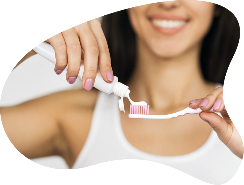Woman_ Applying_ Toothpaste_ On_ Toothbrush PNG