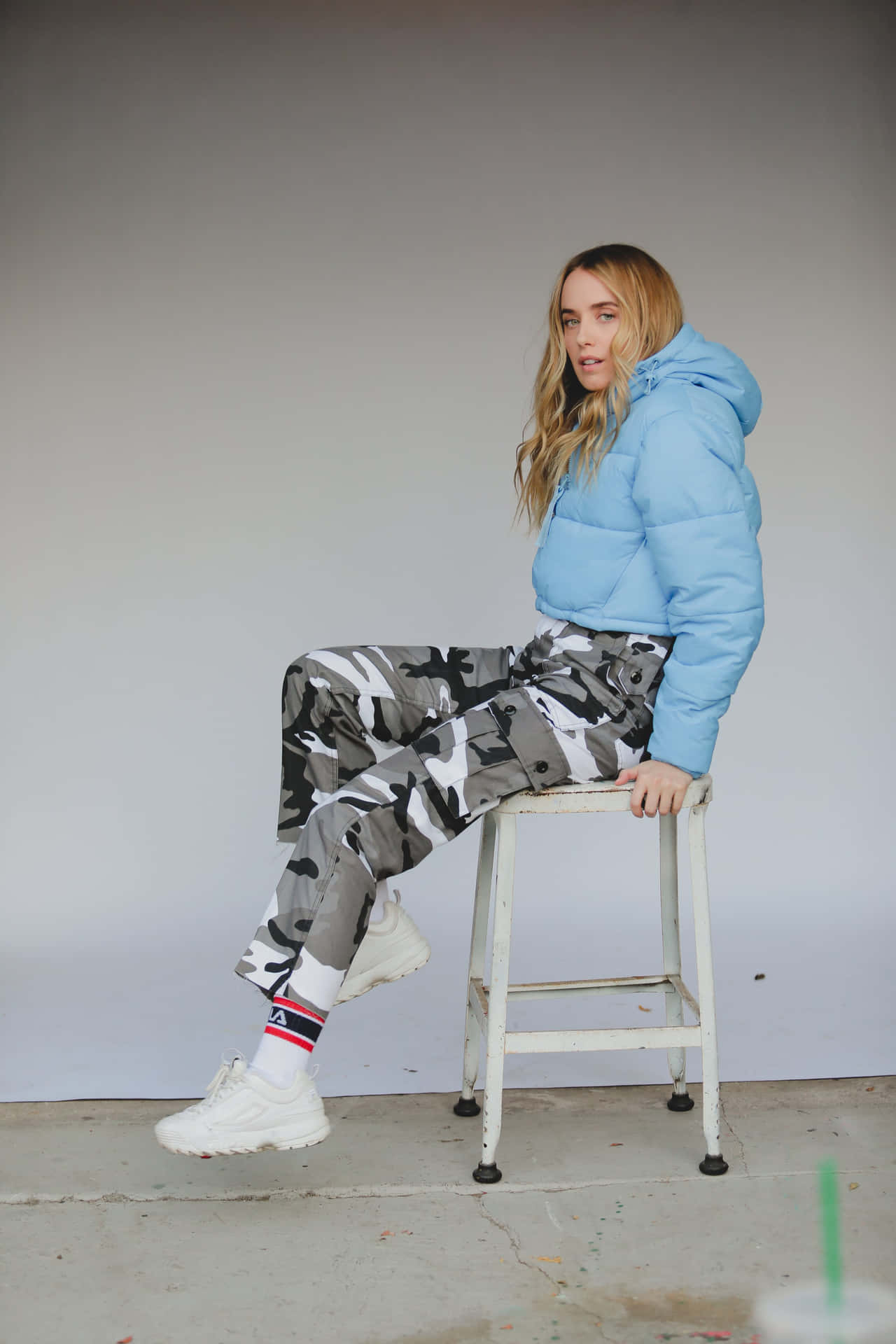 Womanin Blue Puffer Jacketand Camo Pants Wallpaper