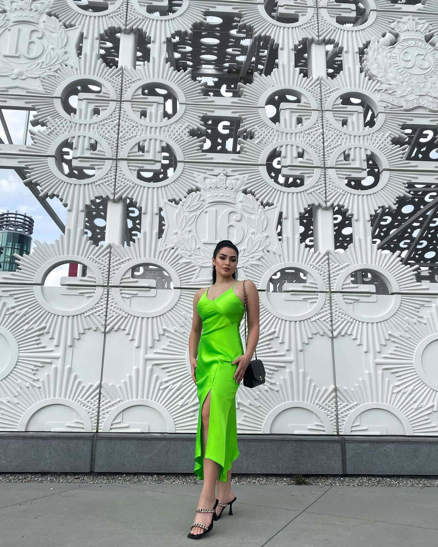 Womanin Green Dress Against Geometric Backdrop Wallpaper