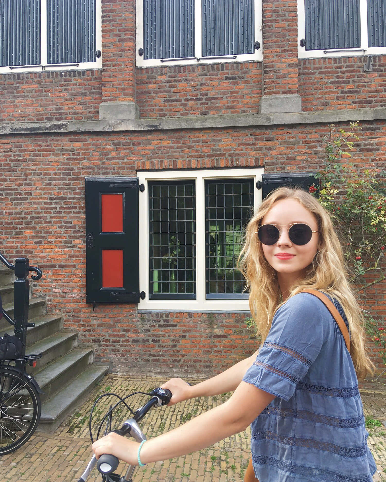 Womanwith Bicycle Near Brick Building Wallpaper