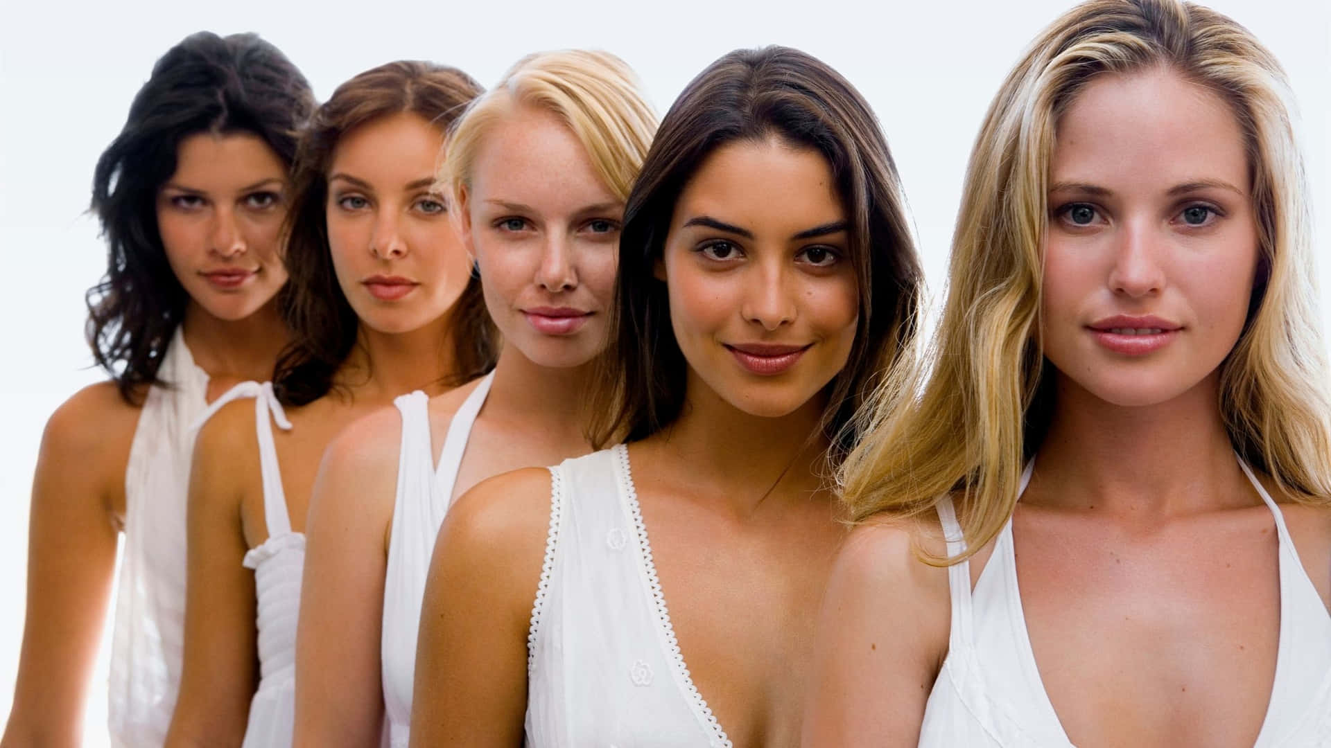 Einegruppe Von Frauen In Weißen Oberteilen Posiert Für Ein Foto.