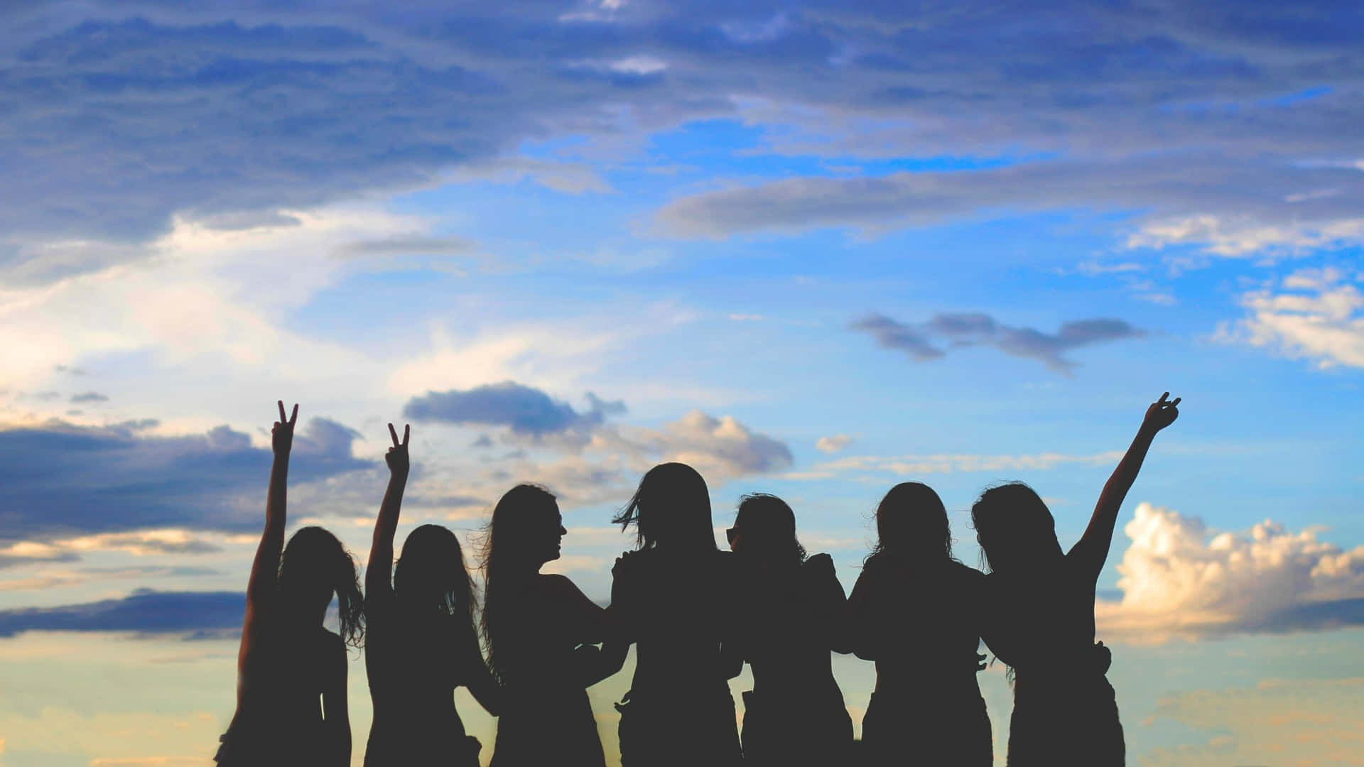 Silhouette Of A Group Of People With Their Hands Raised