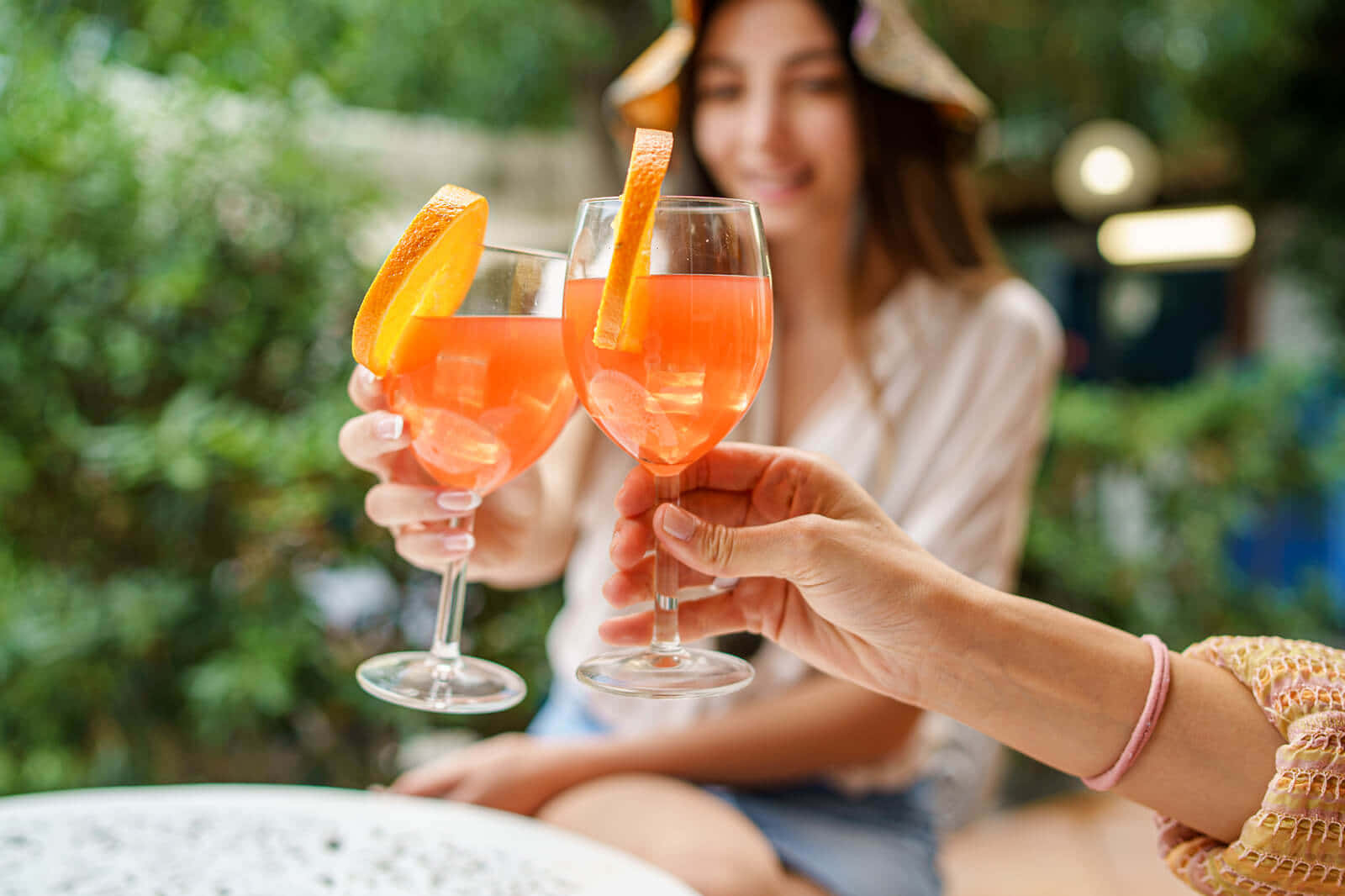 Women Clinking Glasses Of Orange Drinks Wallpaper