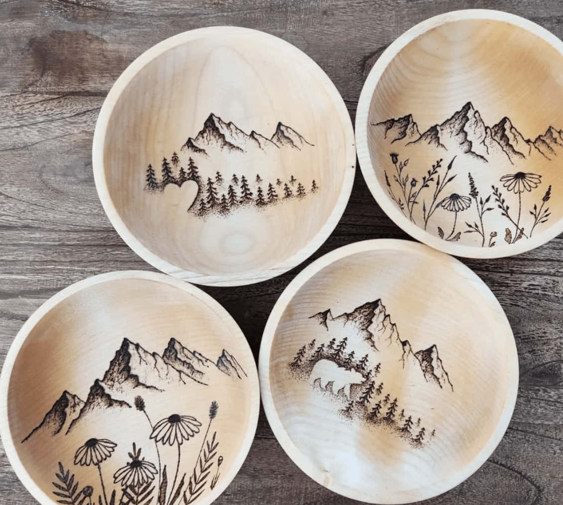 Four Wooden Bowls With Mountains And Trees On Them