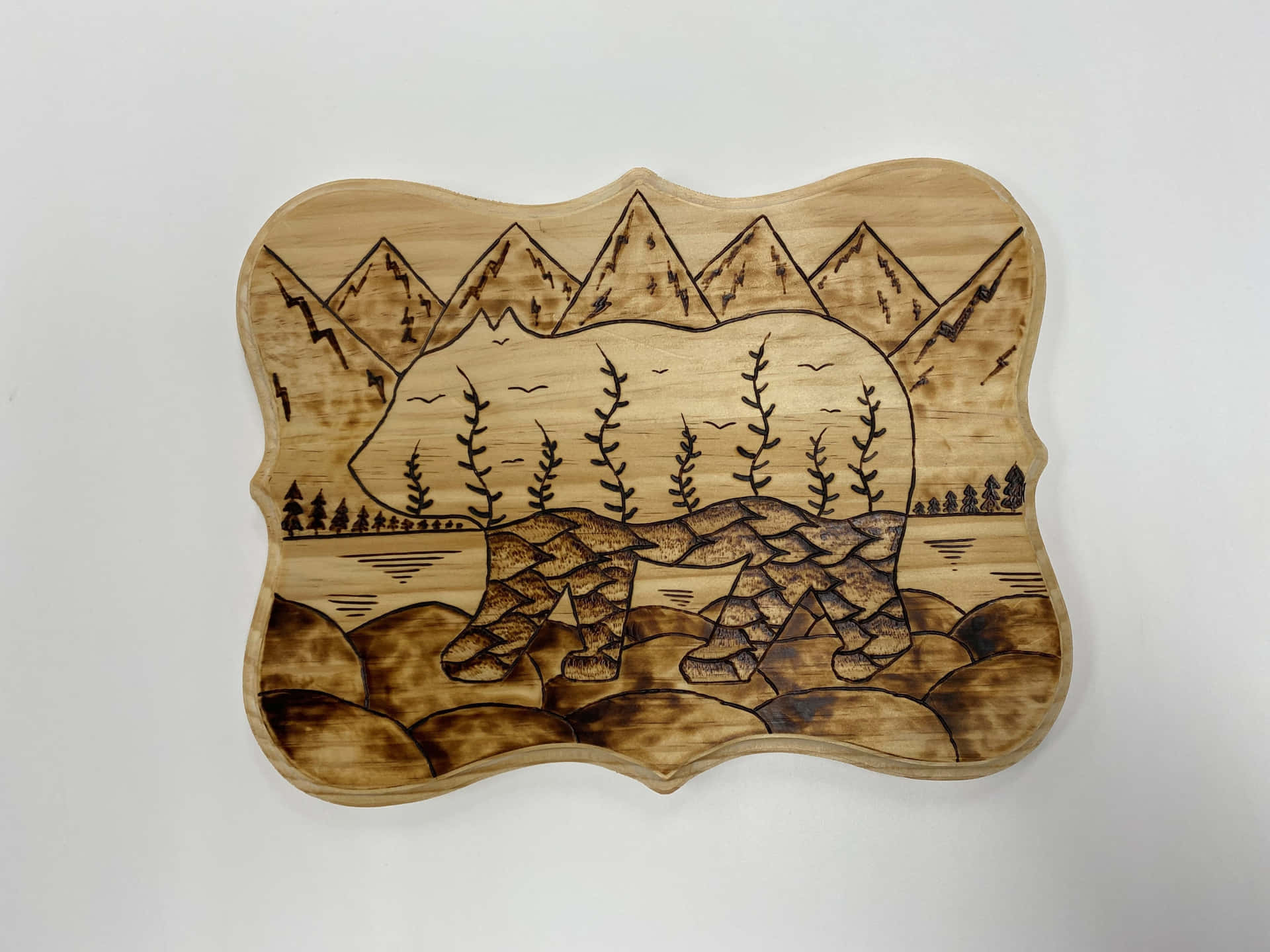 A Wooden Plate With A Bear And Mountains On It