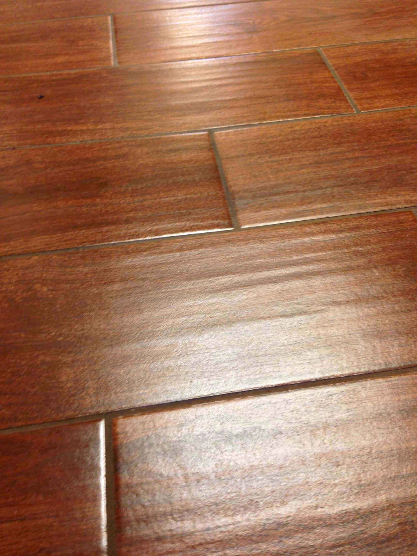 A Close Up Of A Wooden Floor With Brown Tiles