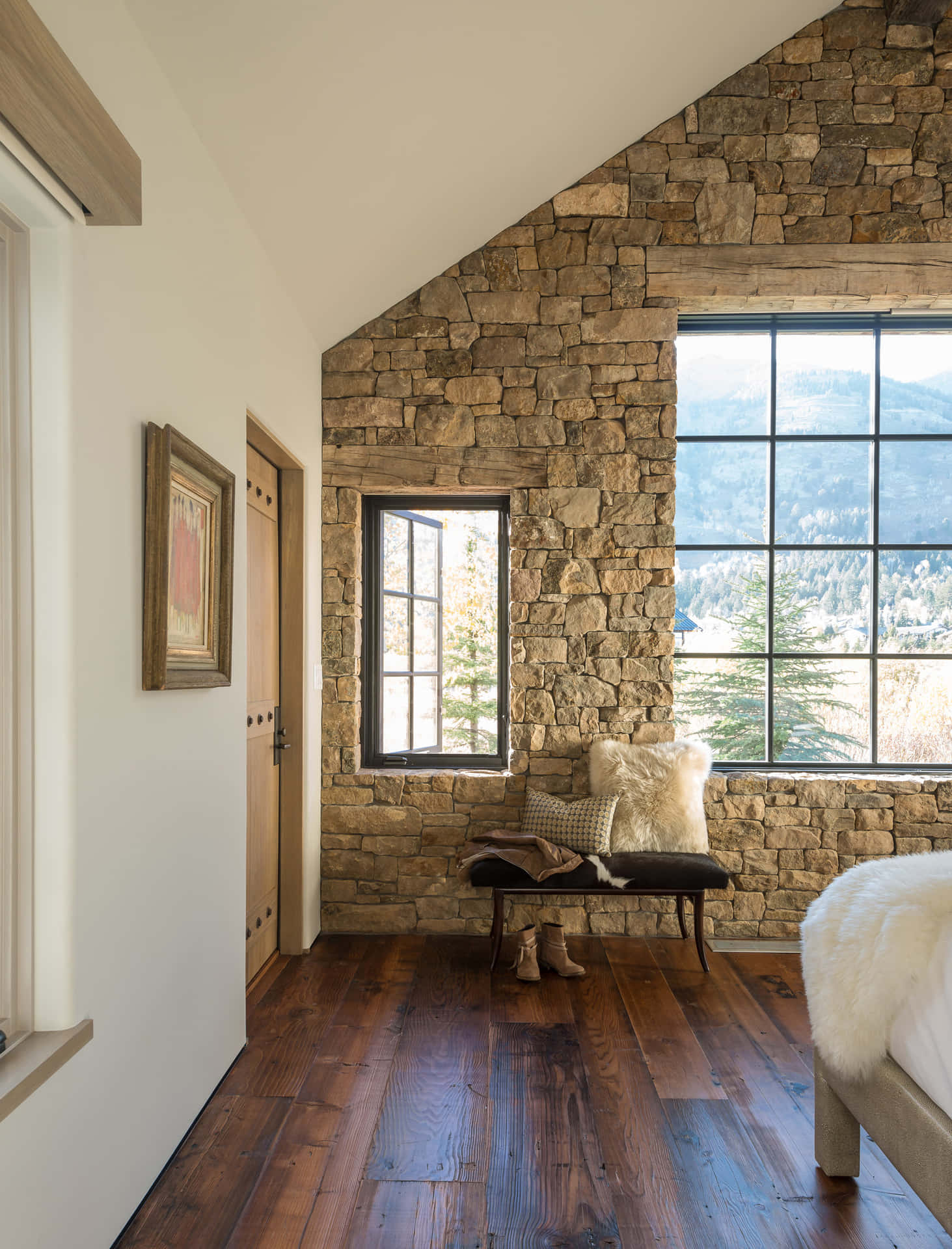 A Bedroom With A Stone Wall And Wooden Floors
