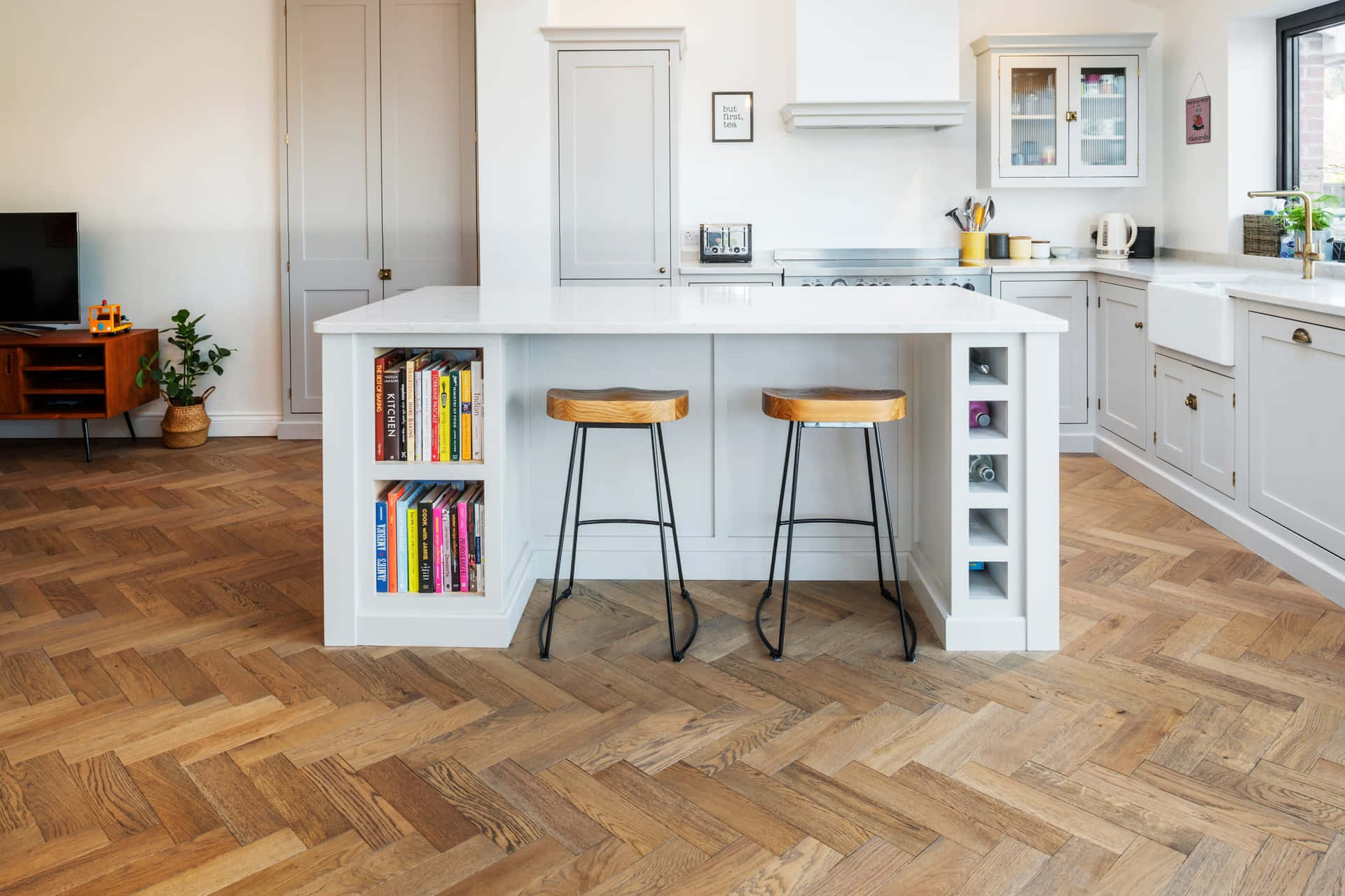 A Kitchen With Wooden Floors And A Bar Stools