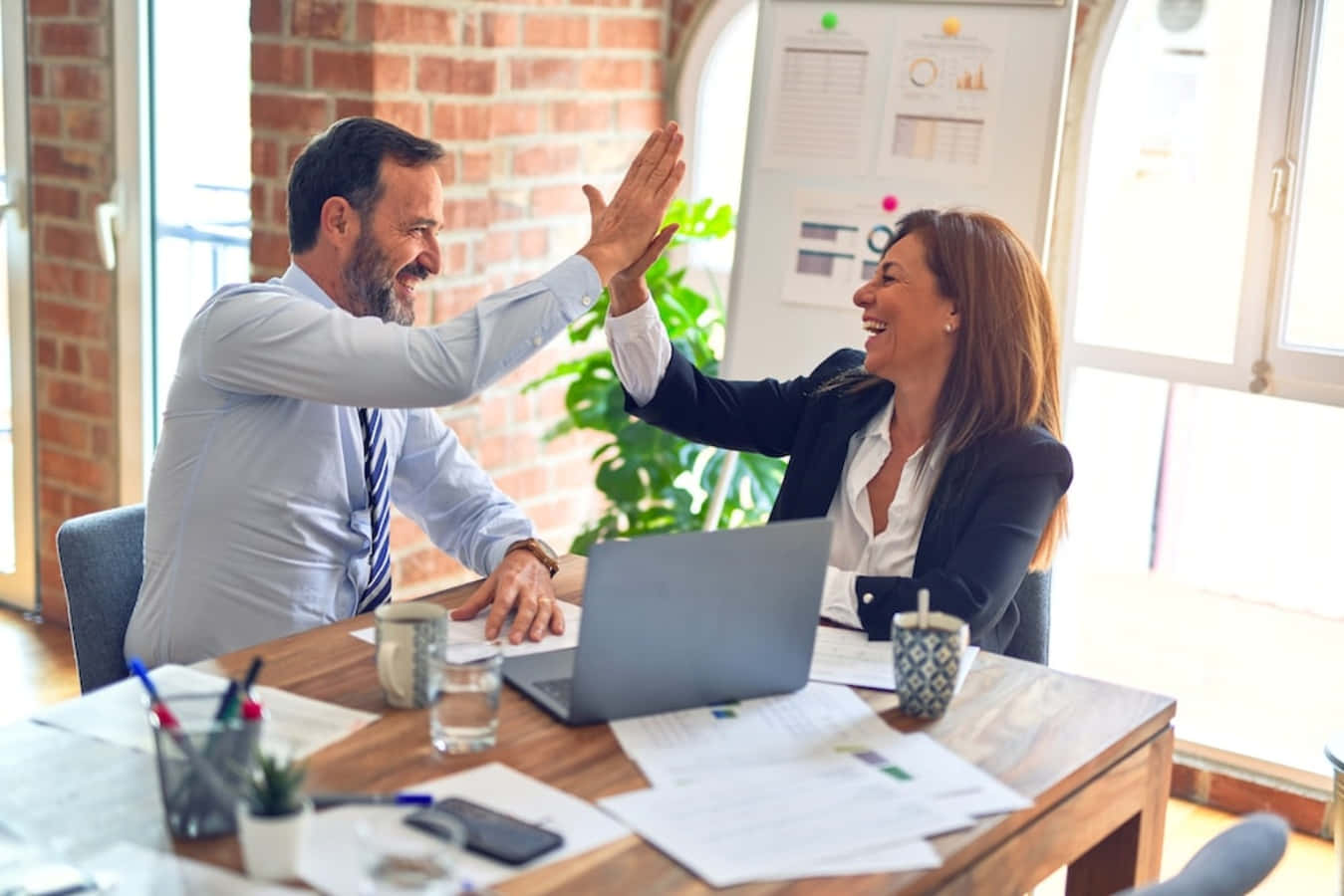 Two Business People High Fiving In An Office