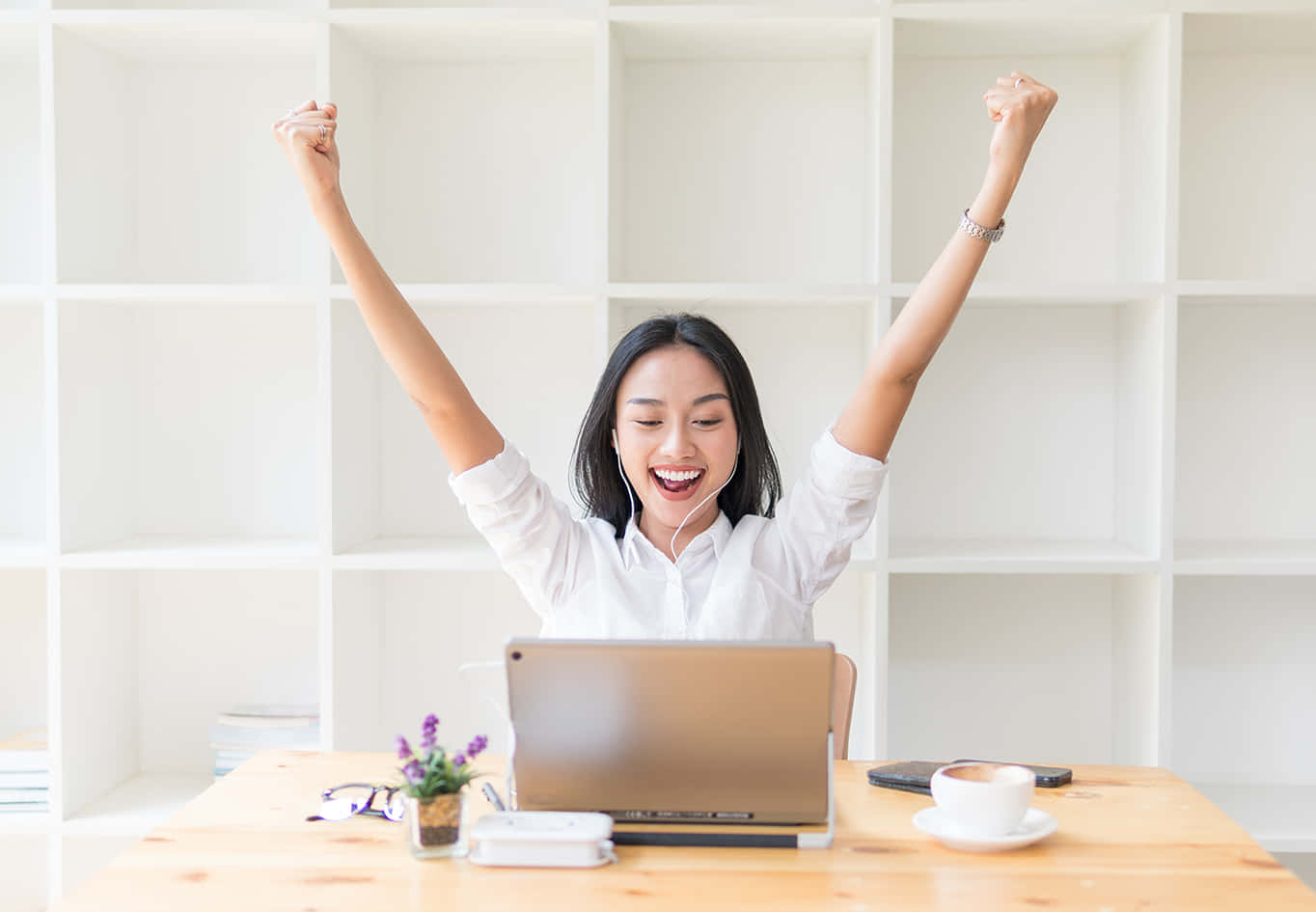 Asian Woman Celebrating Success With Her Arms Raised In The Air