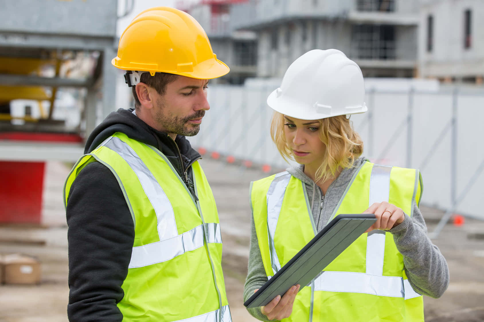 Two Construction Workers Looking At A Tablet
