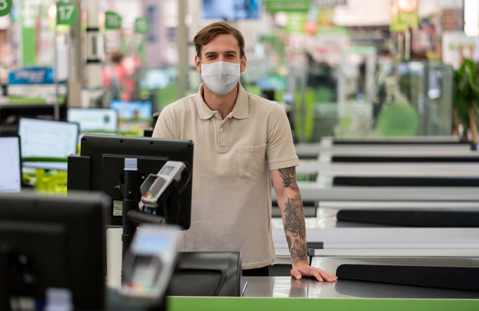A Man Wearing A Face Mask At A Checkout Counter