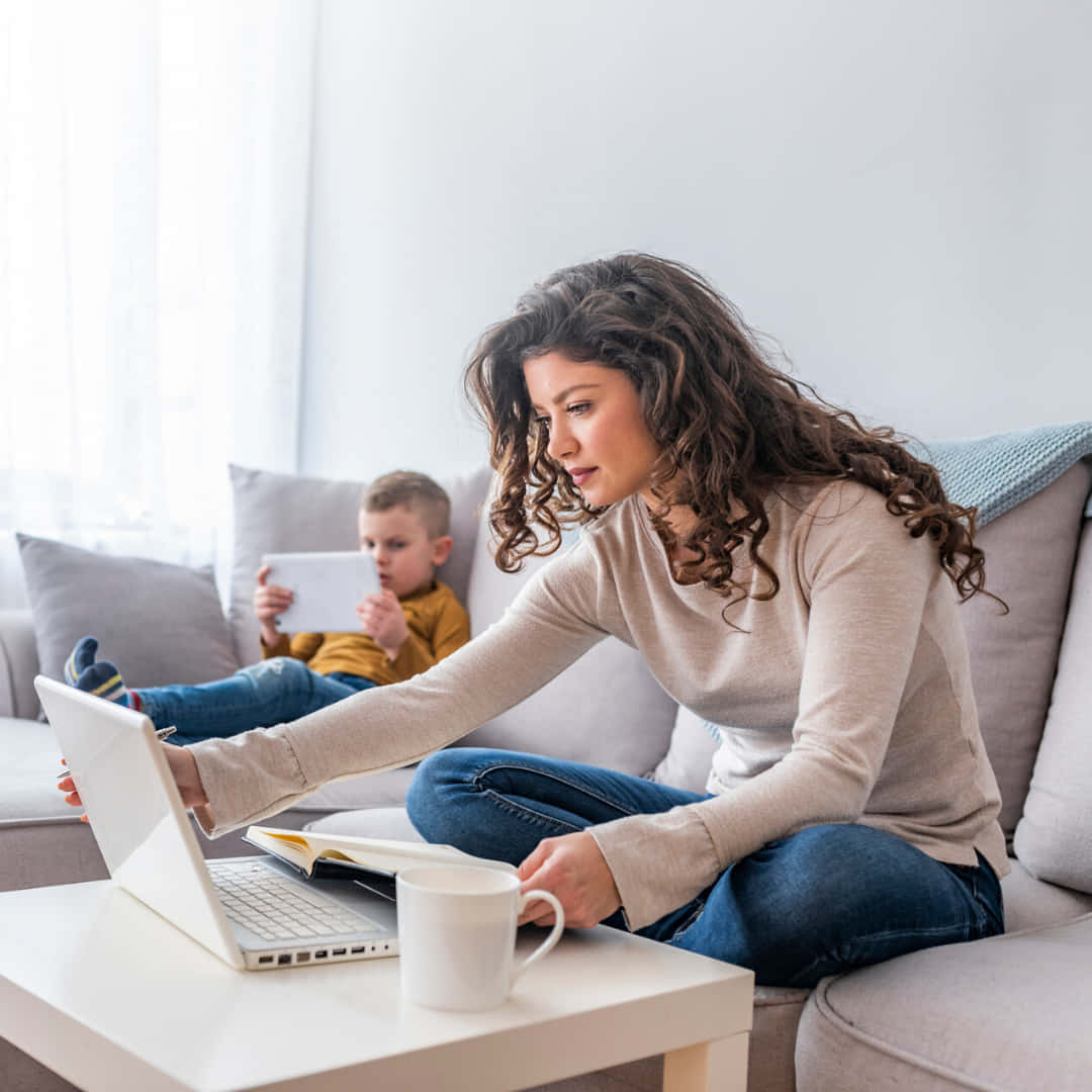 Woman And Child Sitting On Couch Using Laptop