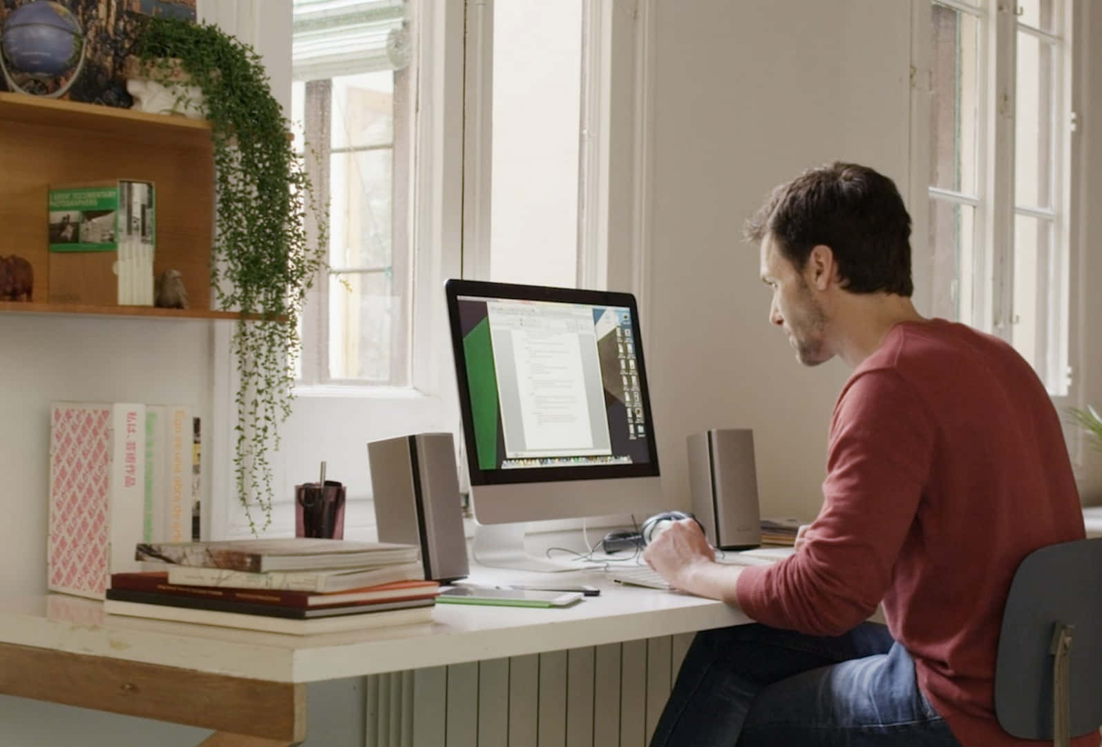 Unhombre Está Sentado En Un Escritorio Con Una Laptop Y Una Planta