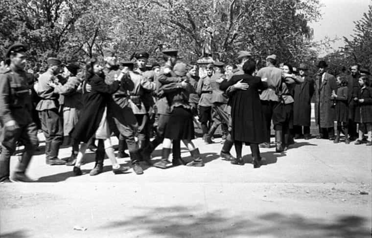A Group Of People In Uniforms Walking In A Park