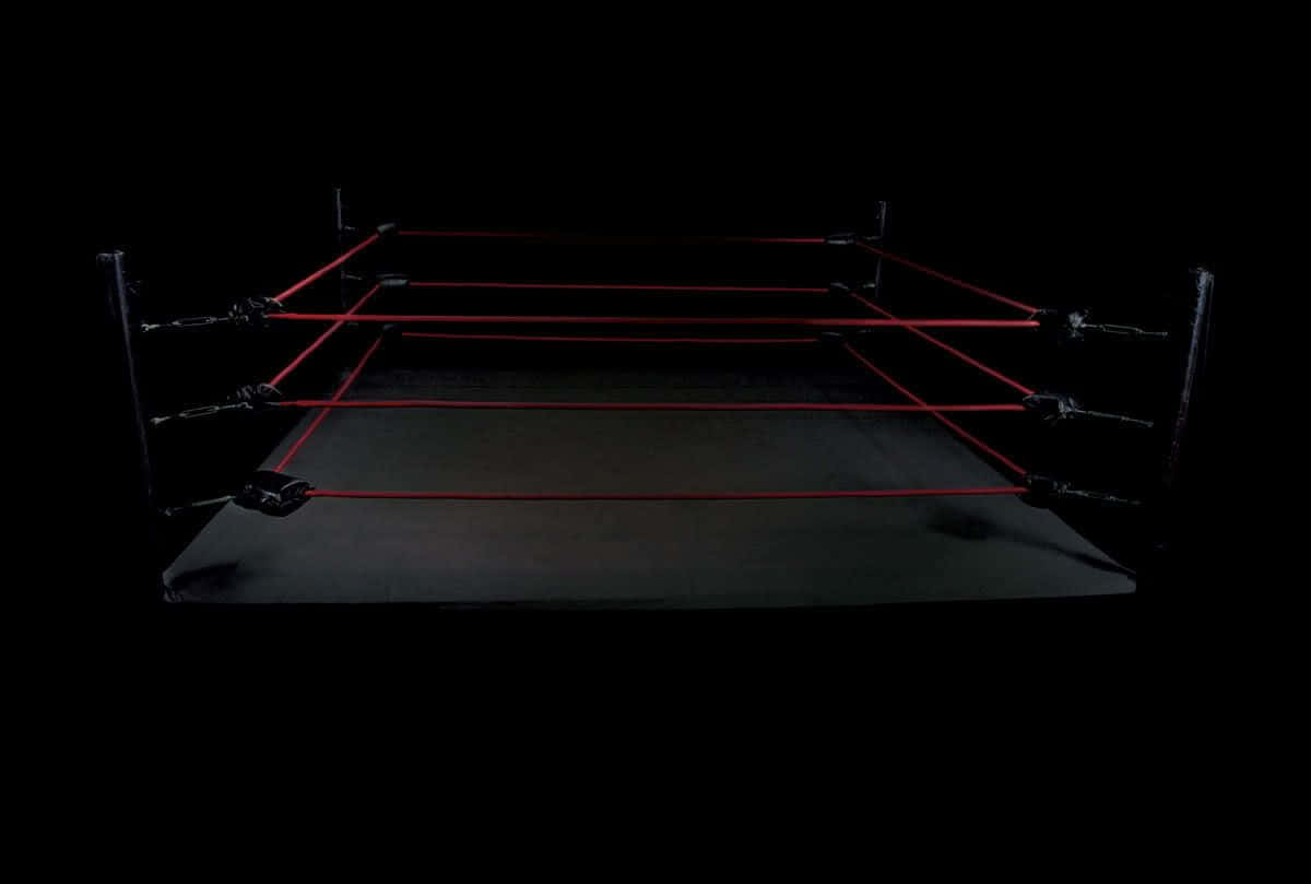 A Wrestling Ring With Red Ropes On A Black Background