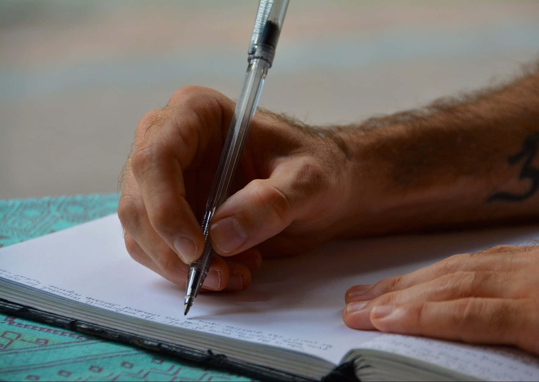 A Man Writing In A Notebook