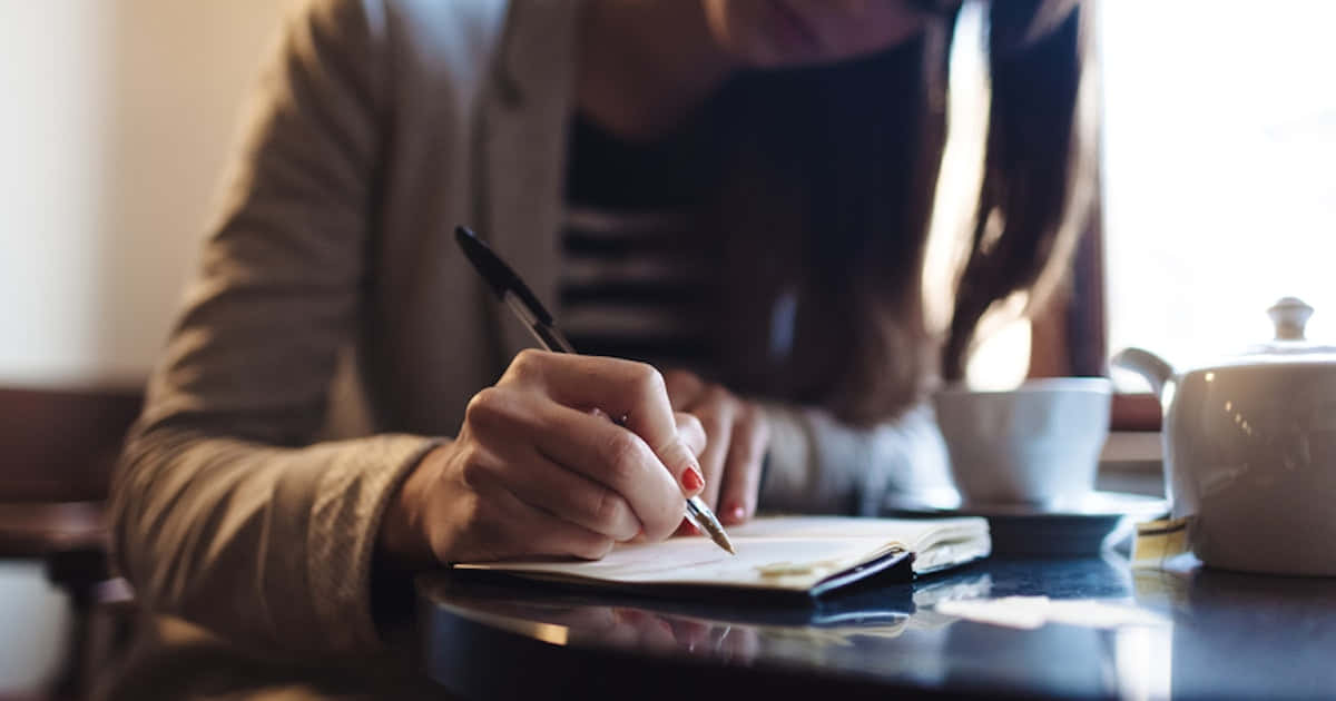 Imagende Una Mujer Escribiendo Con Una Taza De Café