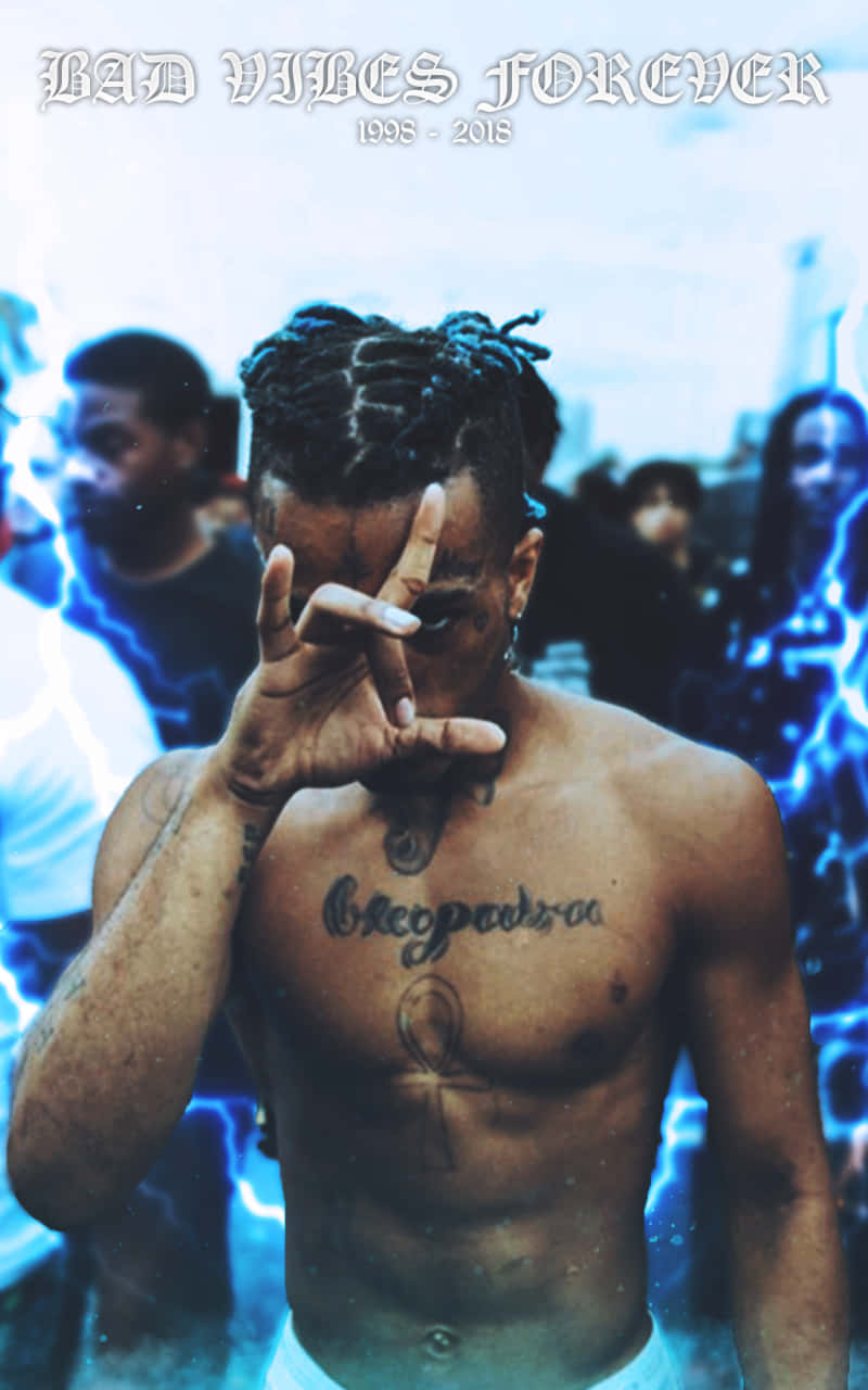 Rapper XXXTentacion with blue hair looking fierce in a photo shoot. Wallpaper