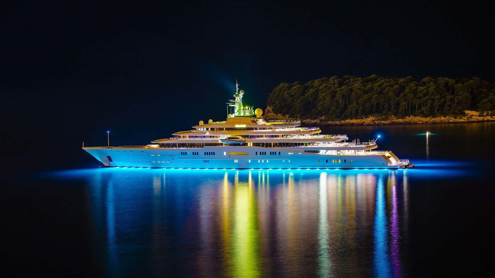 A Large Yacht Is Floating In The Water At Night