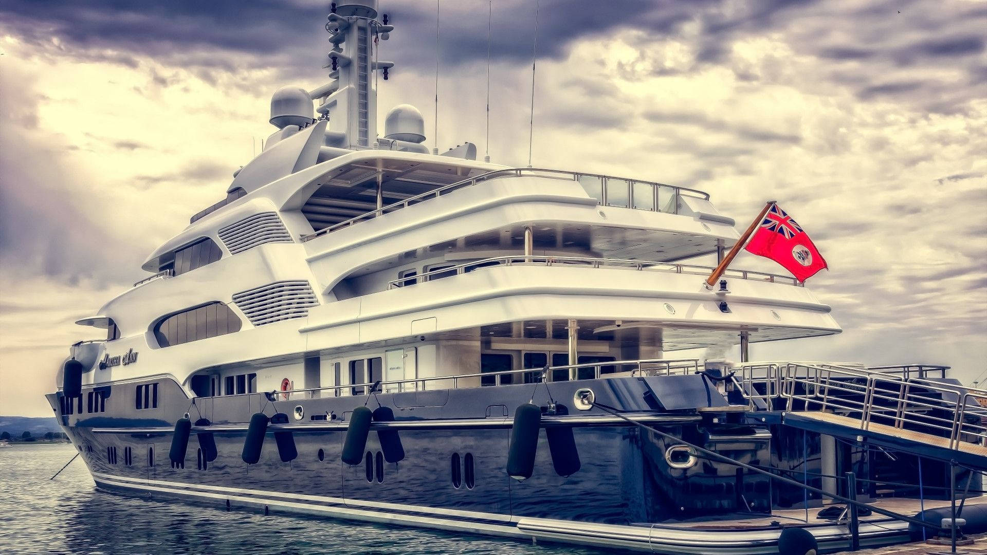 Luxurious Yacht Draped with Red Ensign Wallpaper