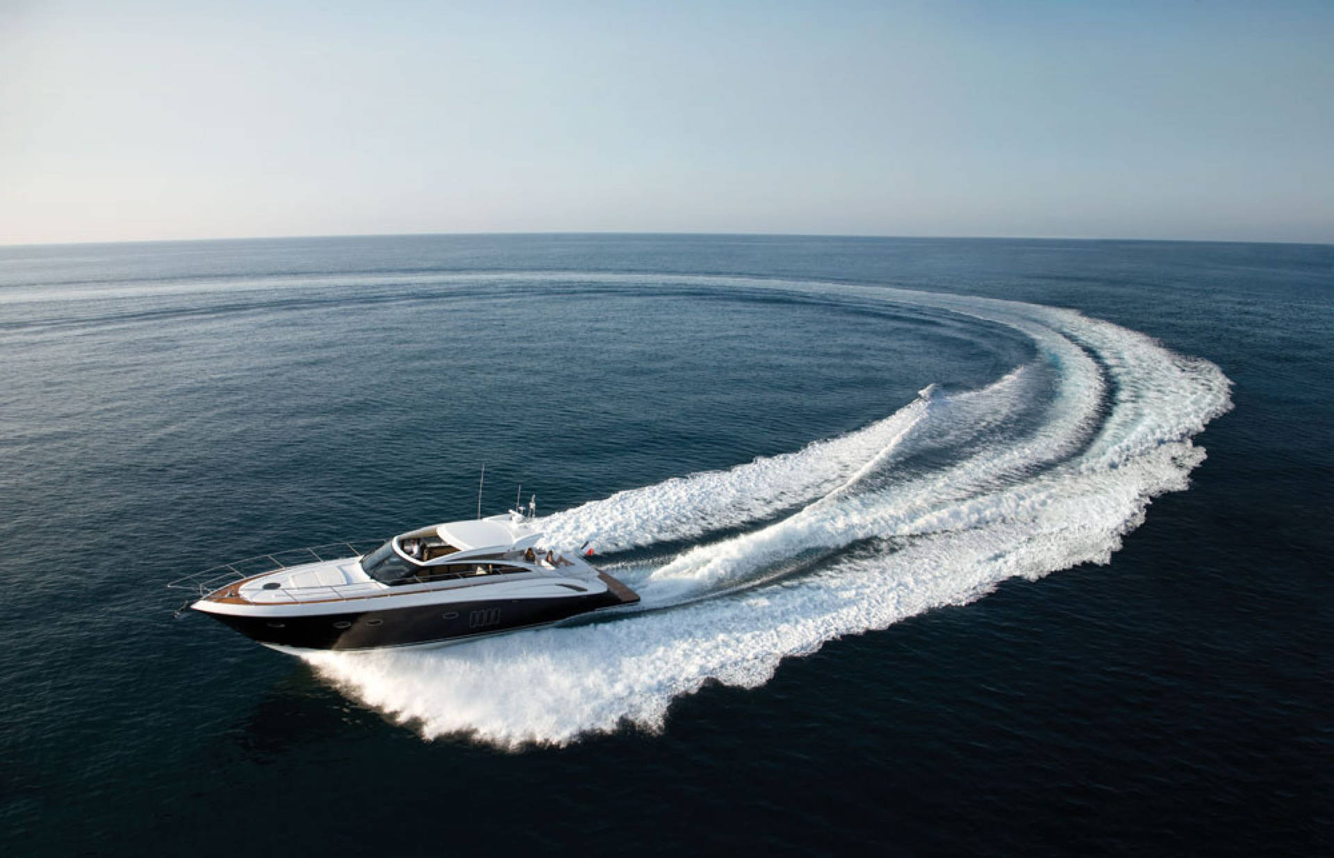 Caption: Elegant Yacht Cutting Through Ocean Waves Wallpaper