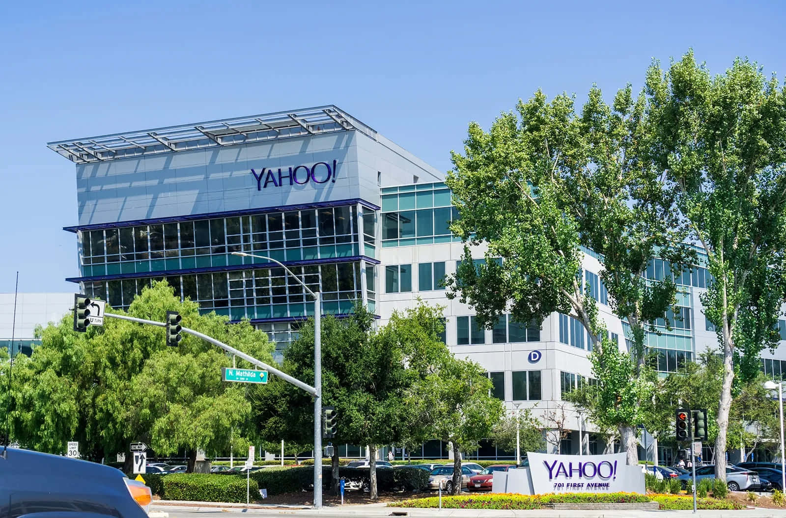 Einauto Fährt An Einem Großen Gebäude Mit Einem Yahoo-schild Vorbei.