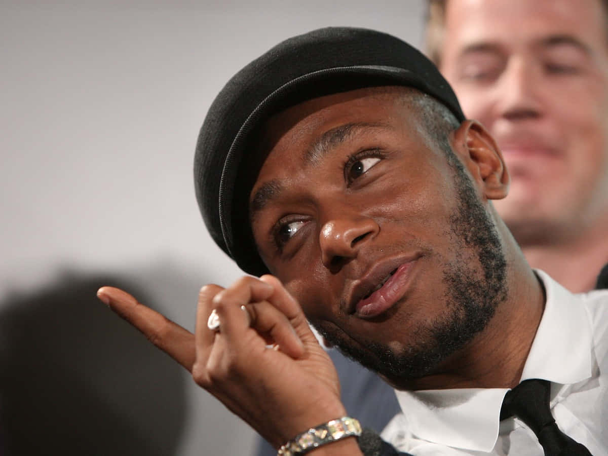 Yasiin Bey Ziet Er Zelfverzekerd En Stijlvol Uit Achtergrond