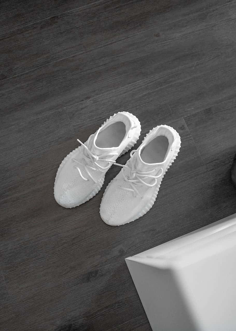 White Yeezy Shoes On The Wooden Floor Wallpaper