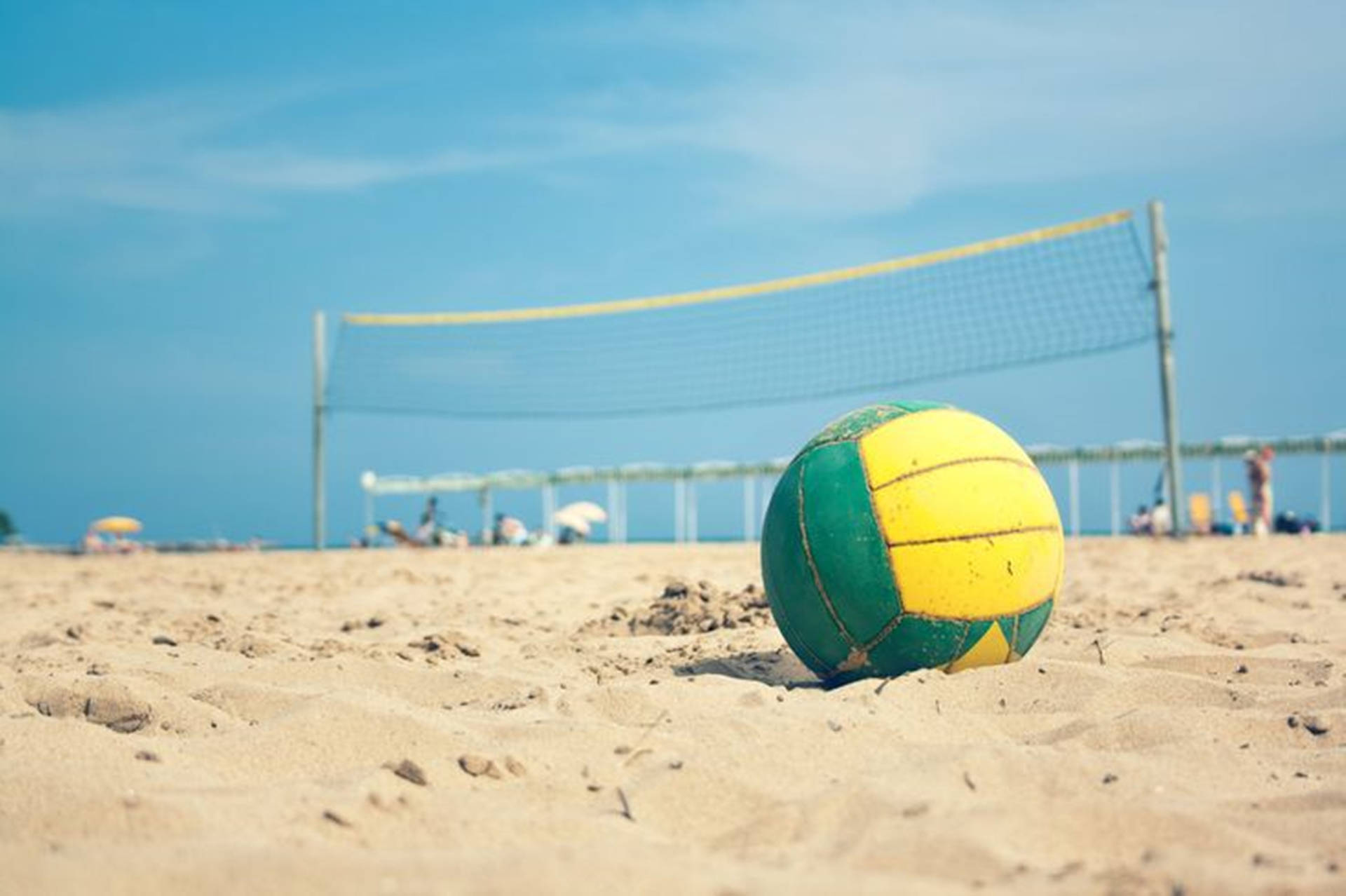 Yellow And Green Beach Volleyball On Sand Wallpaper