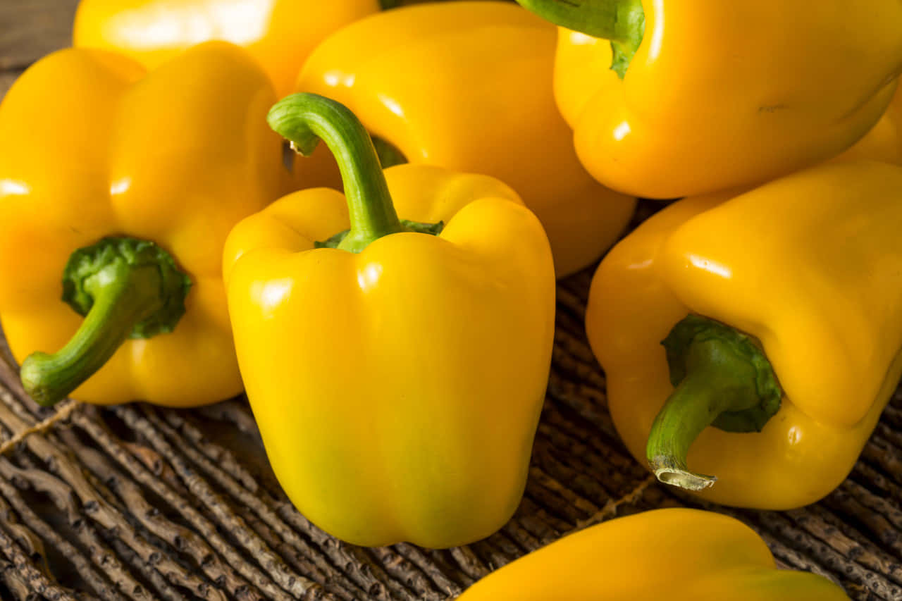 Vibrant Yellow Bell Pepper on a Wooden Surface Wallpaper