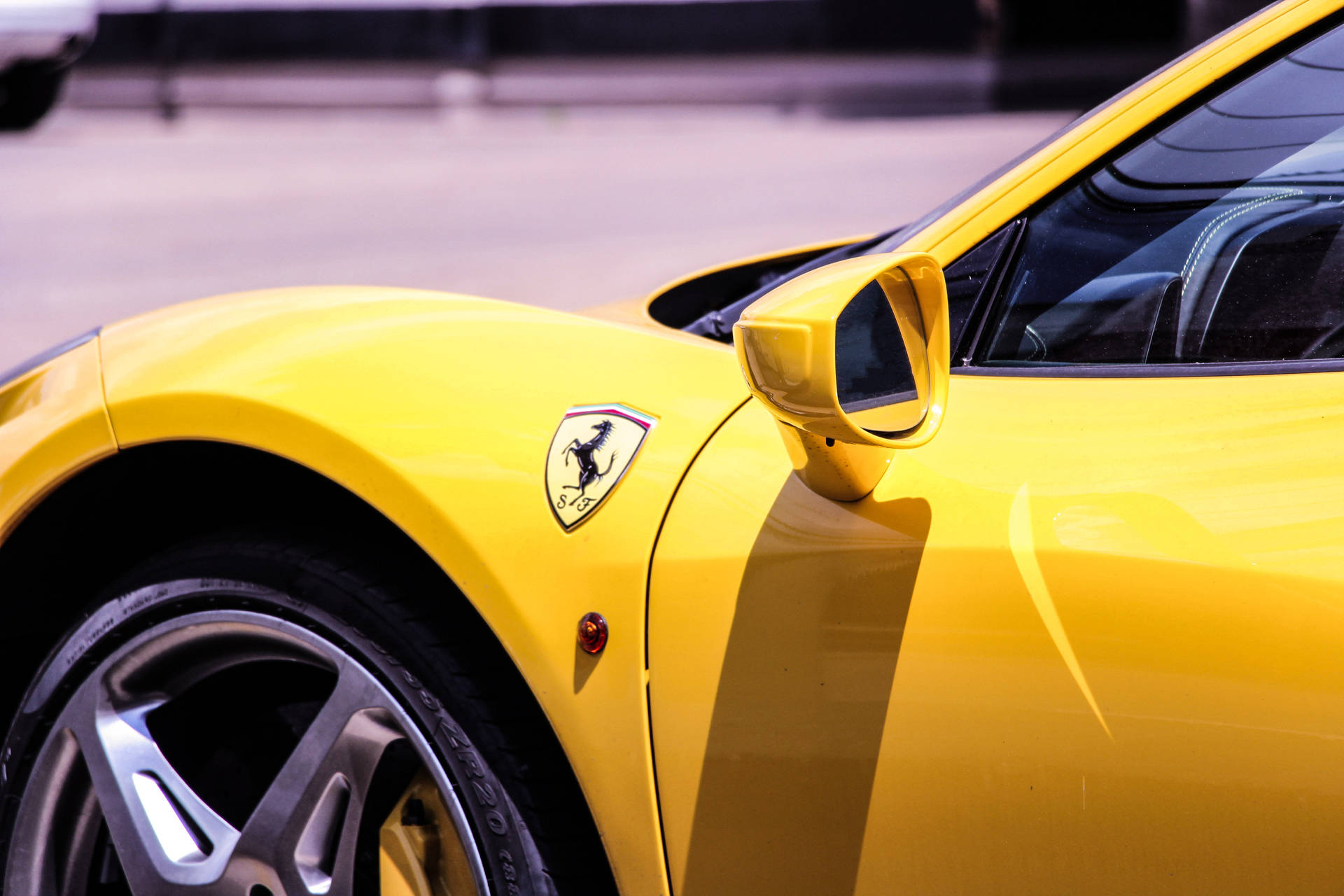 Yellow Ferrari sports car under bright sun close-up wallpaper.