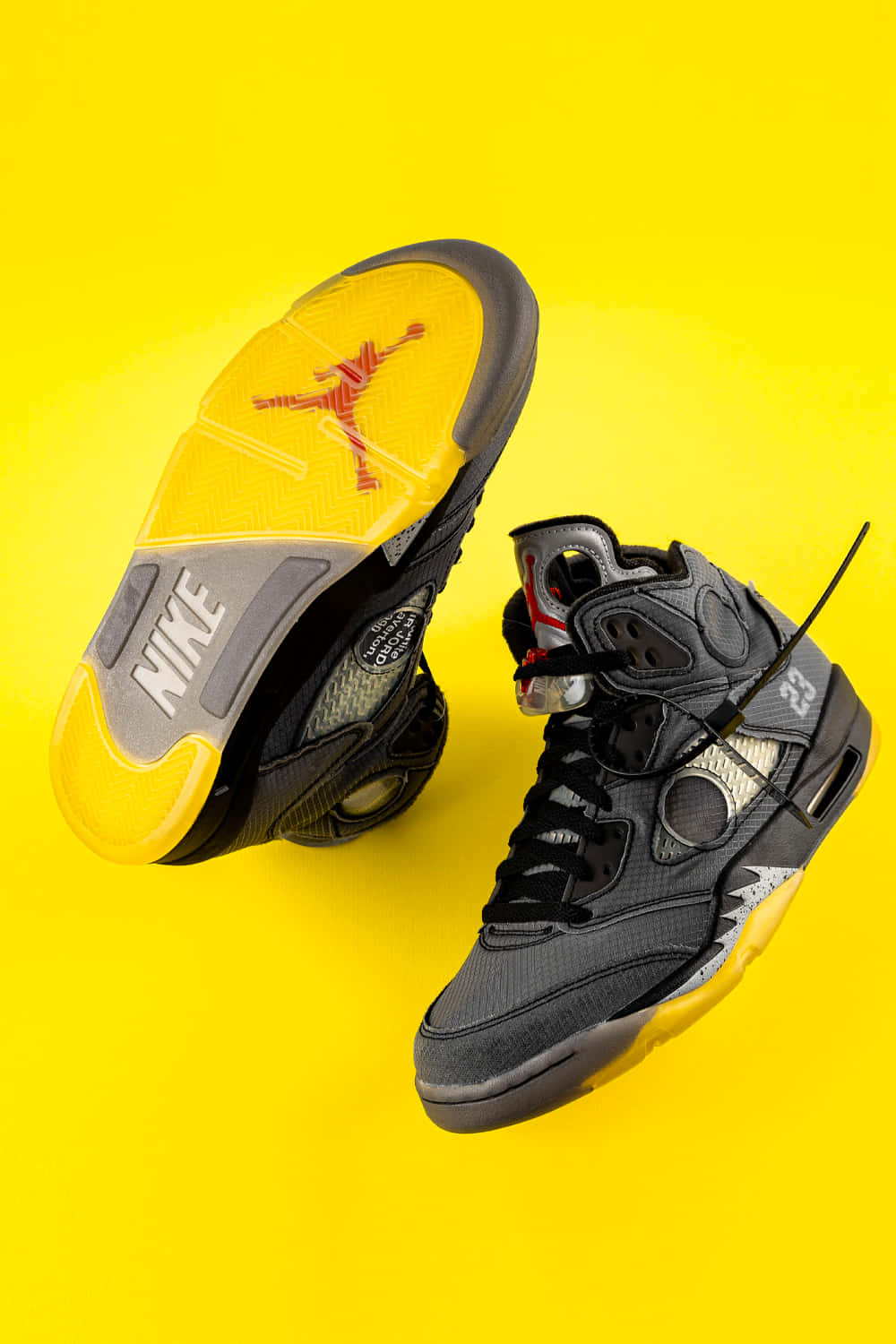 Gult Jordan sneakers skaber et dristigt udtryk mod en denim-struktureret tapet. Wallpaper