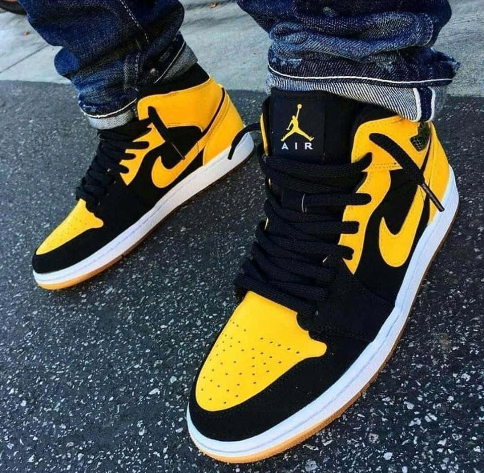 The iconic Air Jordan shoes in a pristine yellow color. Wallpaper