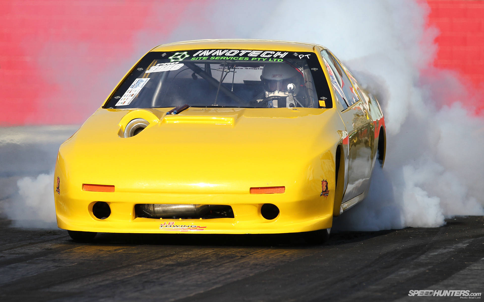 High-Intensity Drag Racing with Yellow Mazda RX-7 Wallpaper