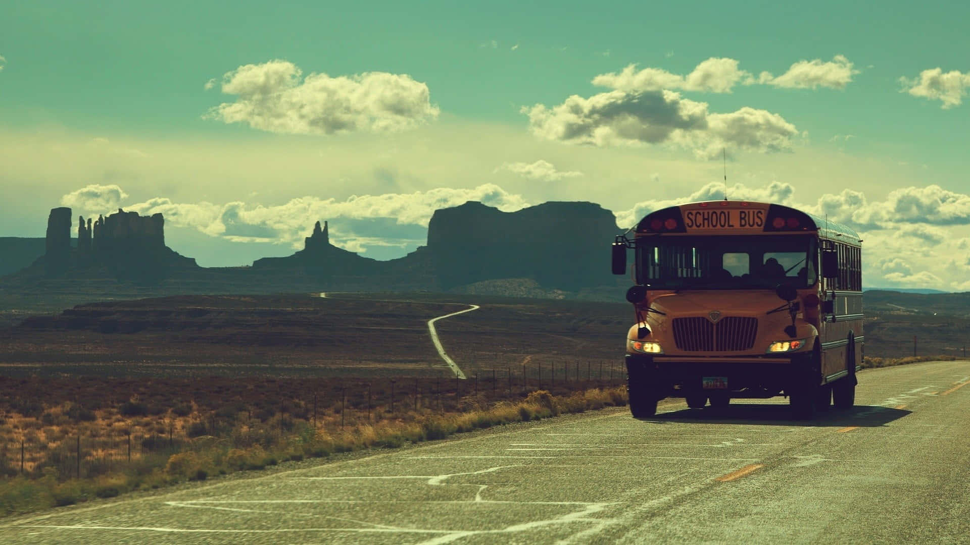 A bright yellow school bus parked outdoors on a sunny day Wallpaper
