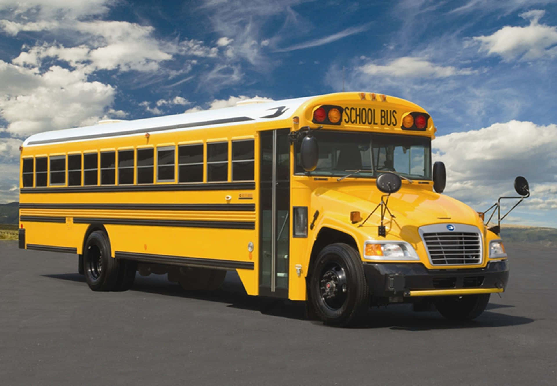Bright Yellow School Bus Parked Outdoors Wallpaper