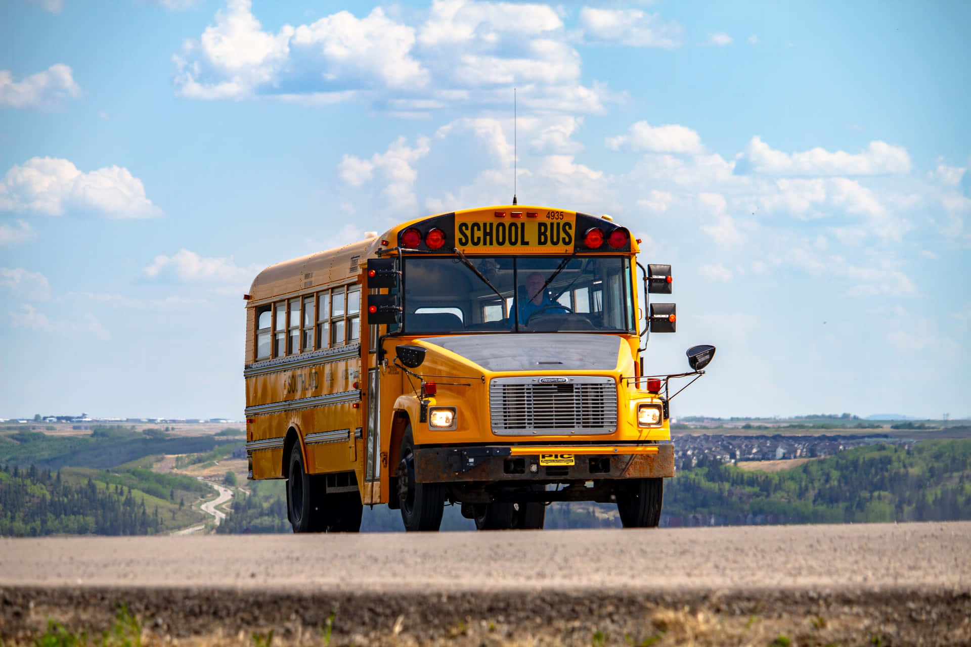 Bright Yellow School Bus on the Road Wallpaper