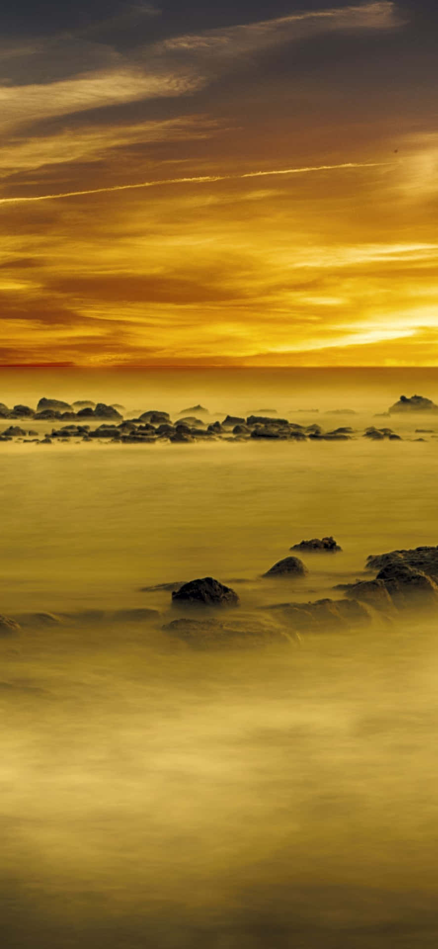 A tranquil yellow sunset over the serene ocean Wallpaper