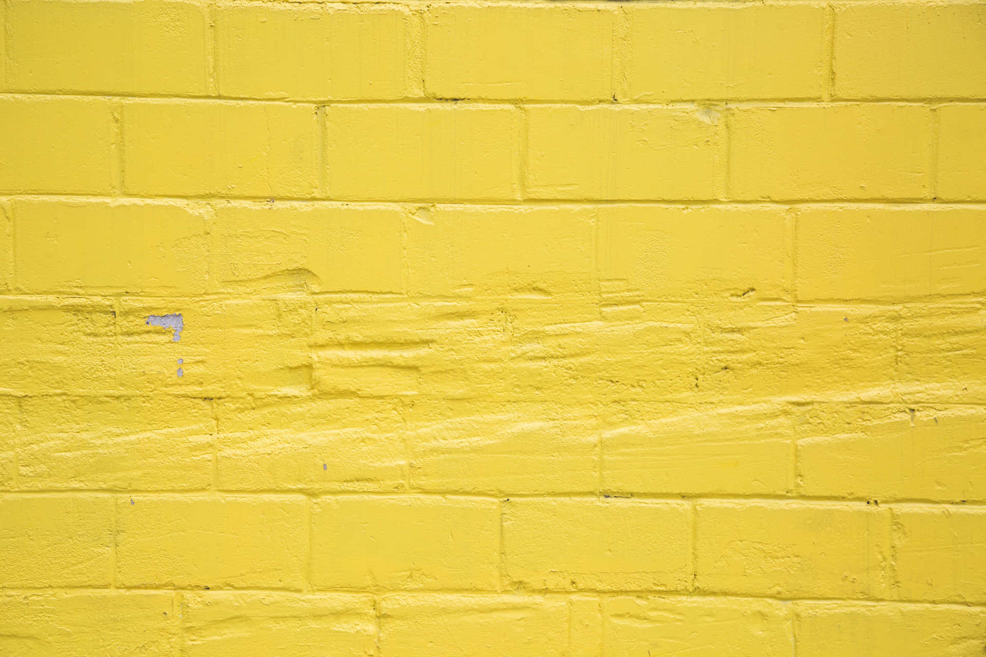 A Yellow Brick Wall With A White Paint