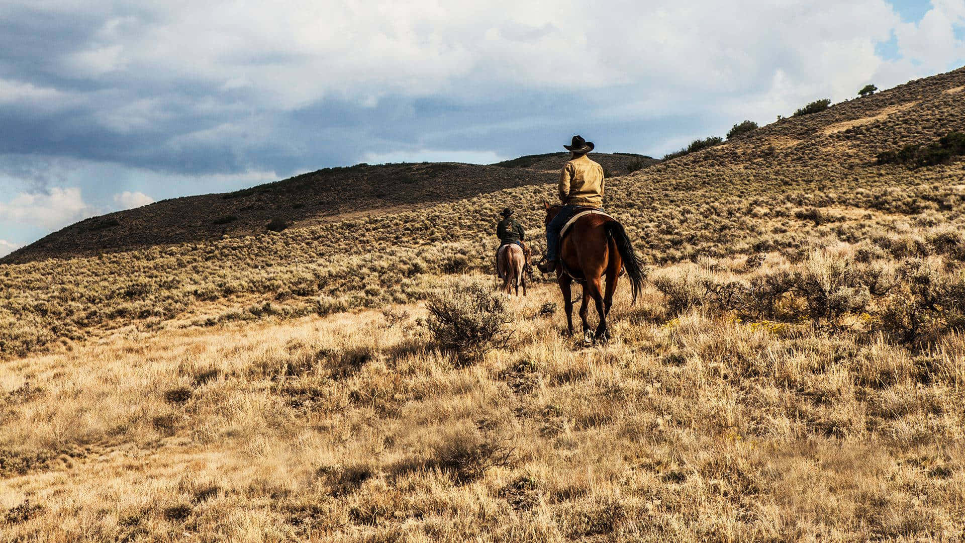 Fondode Pantalla De Yellowstone Con Dos Vaqueros Montando Sus Caballos.