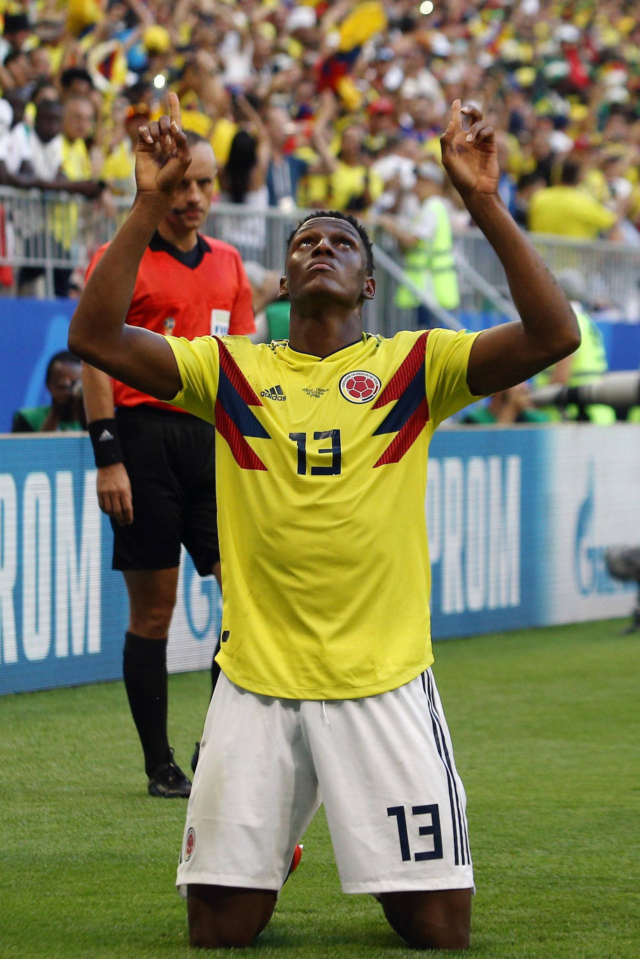 Yerrymina Pekar Och Tittar Upp. (this Sentence Can Be Used As A Description Of A Wallpaper Featuring Yerry Mina, Where He Is Pointing And Looking Up.) Wallpaper