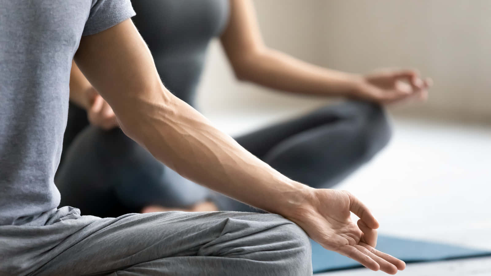Two People Doing Yoga In A Yoga Studio